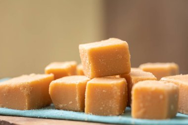 Tahta bir tahtanın üzerinde küp şeklinde Dulce de leche ve görüntünün kompozisyonu peçete. Brezilya yemeği, tatlı..