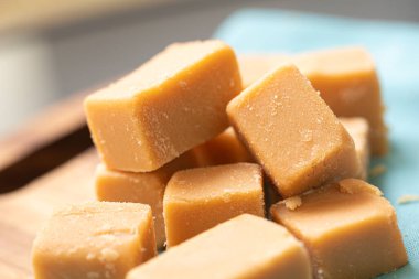 Tahta bir tahtanın üzerinde küp şeklinde Dulce de leche ve görüntünün kompozisyonu peçete. Brezilya yemeği, tatlı..