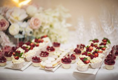 Taze çilek, ahududu ve nane yaprağıyla nefis bir pasta. Meyve ve böğürtlen dolu bir ziyafet masası ve bir sürü tatlı. Şeker çubuğu.