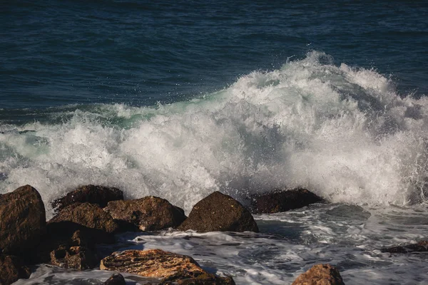 Denizde güzel dalgalar. Güçlü deniz dalgaları kayalara çarpıyor. Sahilde deniz püskürtme hareketi .