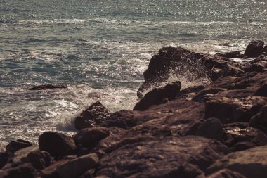 Deniz motifleri. Dalgalar deniz kıyısındaki kayalara vuruyor, oldukça sakin bir deniz..
