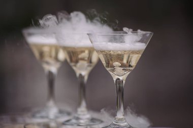 Düğün yemeği servisi. Evlilik kutlaması konsepti. Restoran ve bar alkol menüsü. Lüks içki. Açık hava ziyafeti. Piramit dekorunda kokteyller. Garson bir bardak şampanya getirmiş.. 