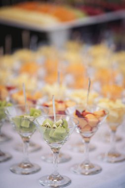 Düğünde yemek servisi. Düğün ziyafeti masası. Meyveli tatlı masa. Partide meyveli çikolata. Lezzetli meyveler aperatifler, tezgahta tatlılar, modern tatlı tabaklar..