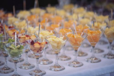 Düğünde yemek servisi. Düğün ziyafeti masası. Meyveli tatlı masa. Partide meyveli çikolata. Lezzetli meyveler aperatifler, tezgahta tatlılar, modern tatlı tabaklar..