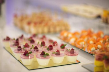 Krem şanti ve ahududulu iki katlı tatlı sufle. Düğün tatlı büfesinde lezzetli tatlılar, pastalar ve pastalar.