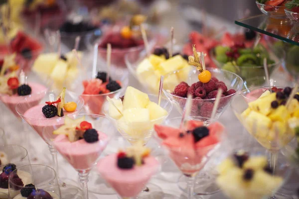Catering on wedding. Wedding banquet table. Sweet table with fruit. Fruit bar on party. Delicious fruits appetizers, desserts on stand, modern sweet tab.
