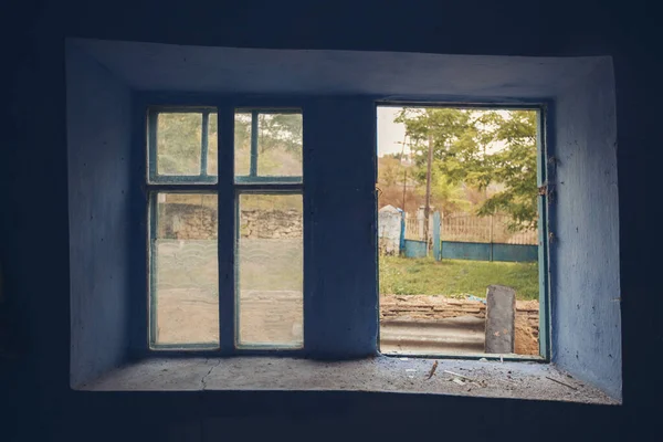 Old abandoned house window. Abandoned building, scraped wall, window frame. Close up view of old beautiful wooden window need of repair and replacement.