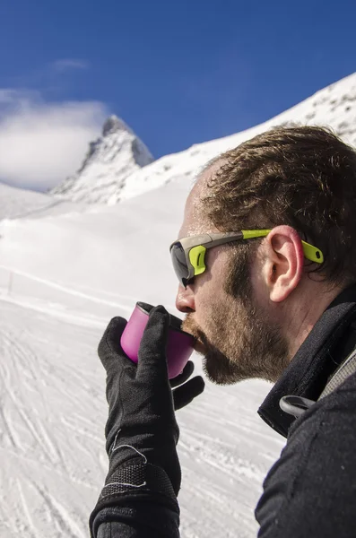 Bergsteiger trinkt Tee aus Thermoskanne — Stockfoto