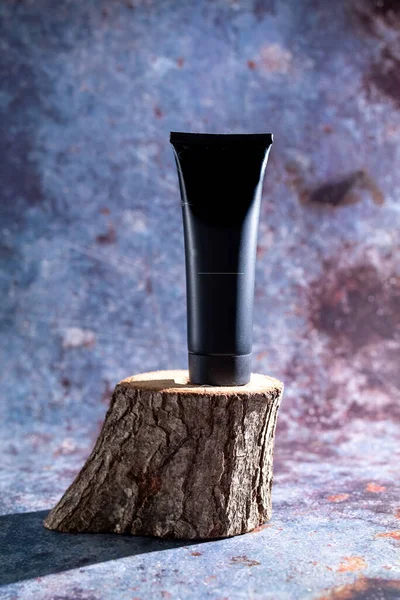 Schwarzer Schlauch auf einem Holzständer auf blauem Hintergrund — Stockfoto
