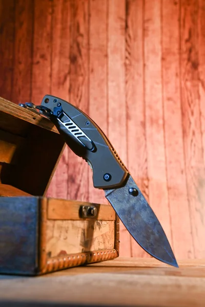 Cuchillo afilado sobre fondo de madera con joyero vintage — Foto de Stock