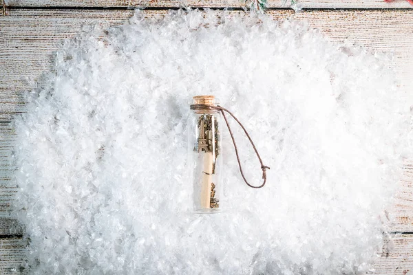 Ένα δώρο σε ένα διαφανές μπουκάλι σε φόντο χιονιού — Φωτογραφία Αρχείου
