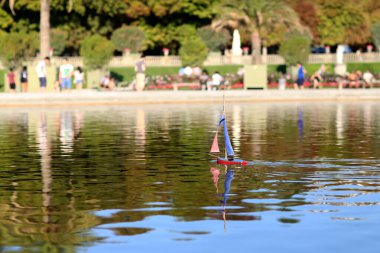 Fotoğraf: Saf suda hızla yelken açan yalnız oyuncak tekne teması