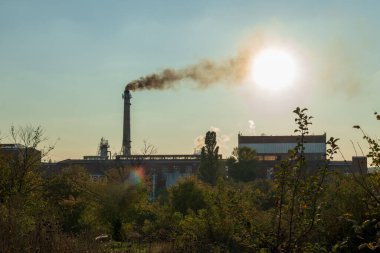 Photo on theme of poisonous thick smoke from high chimney of large plant that pollutes nature