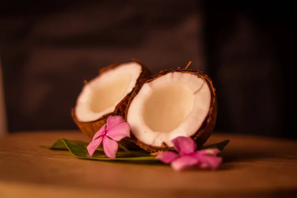 Grounded coconut flakes,half coconut with green leaves wooden on background,hd footage of coconut milk and half coconut on wooden selective focus on subject,