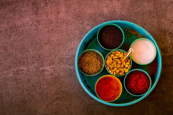 Essential Indian spices in an Indian spice box with copy space background,Cardamom, turmeric, chilli powder, salt,mustard seeds,cumin, selective focus
