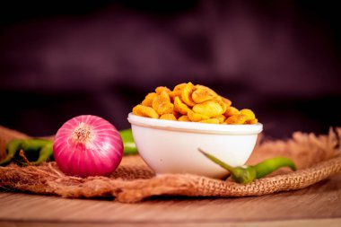 Masala ya da baharatlı Çin yemeği çok popüler bir Gujarati aperatifi, beyaz kase, masala atan Namkeen ya da ahşap masada kavrulmuş baharatlı fıstık ve soğan ve yeşil biber.