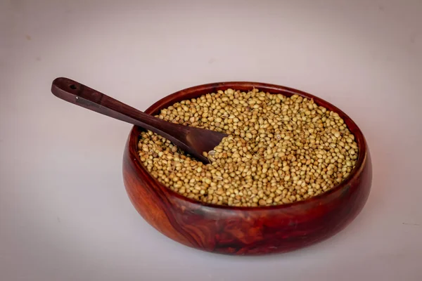 Organic Dried coriander seeds (Coriandrum sativum) in wooden bowls with spoon,dry coriander seeds in spoon,selective focus on subject,dried coriander seed bowl