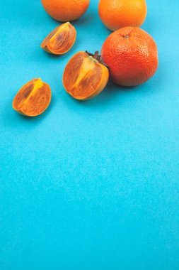 Mavi arka planda meyve portakalları ve hurmalar.