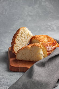 Gri arka planda şekerli kalp şeklinde taze pişmiş beyaz ekmek. Yanında bir bardak süt var..