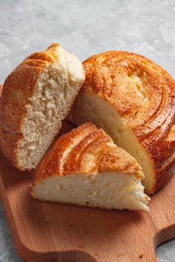 Gri arka planda şekerli kalp şeklinde taze pişmiş beyaz ekmek. Yanında bir bardak süt var..