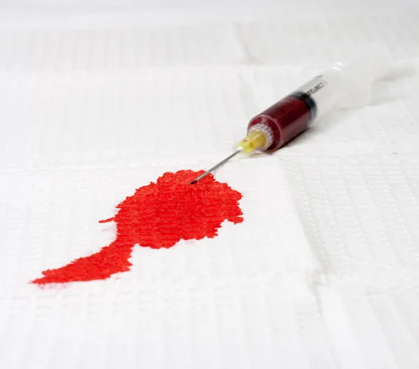 Blod på vita drapera kommer från nålen — Stockfoto