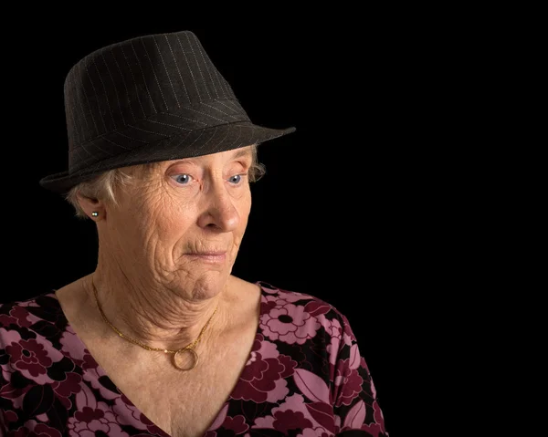 Ηλικιωμένης με ένα σοκαρισμένος βλέμμα στο πρόσωπό της, φορώντας ένα καπέλο — Φωτογραφία Αρχείου
