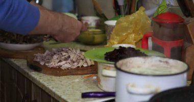 Asya mutfağı. Aşçı yemeği hazırlamak için tavuk etini küçük parçalara ayırır. Yakın plan..