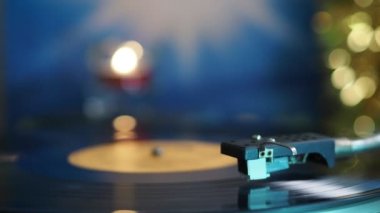Vinil plak çalar. Plaklar, yanan mum ve beneklerin neşeli arka planında dönüyor..