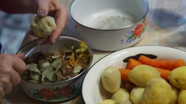 Asya mutfağı, basit yiyecekler. Yumurtayı temizleyen ve kabuğunu bir fincan haşlanmış patatesin yanına koyan bir kadının elleri. Yakın plan..