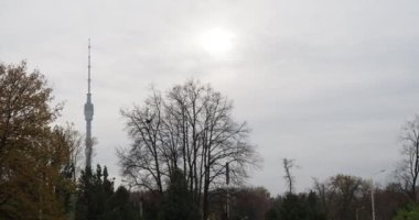 Moskova, Rusya-Ekim, 20, 2021. Güneş çerçevenin içinde. Bulutlu bir günde şehir parkından Ostankino TV kulesinin görüntüsü. Çeviriyorum. Elle tutulur.