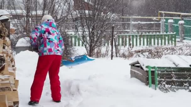 Vinter Kvinna Varma Färgade Kläder Tar Bort Snö Med Plastspade — Stockvideo