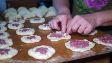 Asya mutfağı. Yaşlı bir kadın turtaları etle doldurur ve kızartma tavasında yağda kızartmak için özel olarak sarar. Sibirya 'da. Yakın çekim..