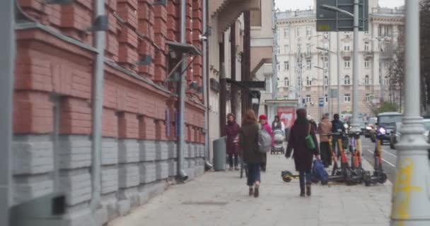 2021年10月16日 莫斯科 孩子们骑着自行车和电动车在车辆行驶的道路旁边的过路人之间穿梭 手牵手 — 图库视频影像