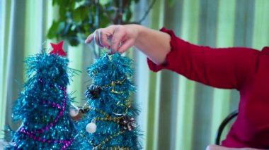 Tatil sezonu. Mutlu yaşlı bir kadın bayram için küçük bir Noel ağacı süsler. Yakın plan..