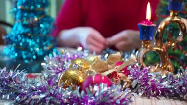 Tatil sezonu. Mutlu yaşlı bir kadın bayram için küçük bir Noel ağacı süsler. Yakın plan..