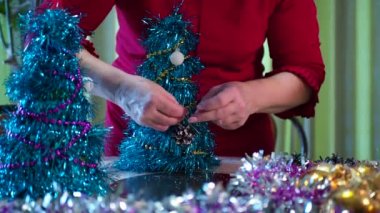 Tatil sezonu. Mutlu yaşlı bir kadın bayram için küçük bir Noel ağacı süsler. Yakın plan..