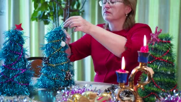 假日季节 一位快乐的老妇人装饰着一棵小圣诞树过节 后续行动 — 图库视频影像