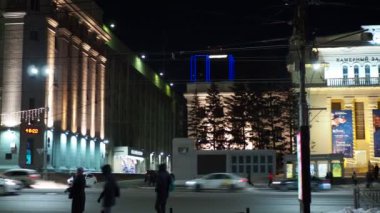 Güzel aydınlatılmış konser salonunun arka planında toplu taşıma durağı var. Elle tutulur.