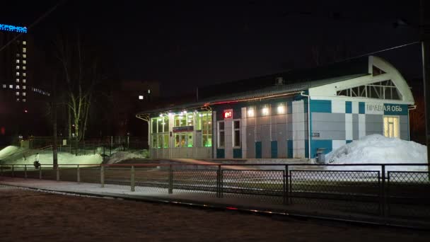 ロシアのノヴォシビルスク 2021年12月12日 冬の夜に市内の照明ステーションで電車の到着 手を握って — ストック動画