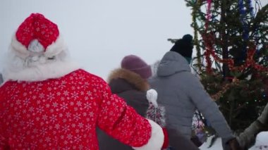 Berdsk, Rusya, 25 Aralık 2021. Tatil sezonu. Çocuklar ve yetişkinler Noel ağacının etrafında dans eder. Sibirya.