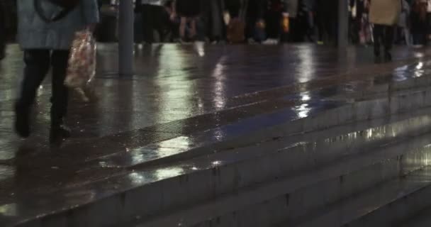 在夜市 行人沿着湿淋淋的人行道走着 反射着灯光 手牵手 — 图库视频影像