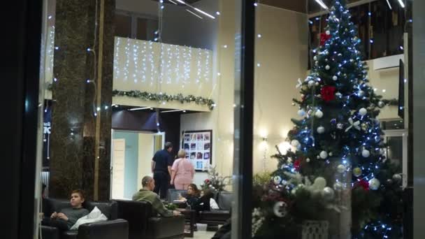 2022年1月4日 俄罗斯伯德斯克 假日季节 宾馆的灯光明亮的窗户 大厅里有一棵圣诞树 人们正在休息 手牵着 西伯利亚 — 图库视频影像