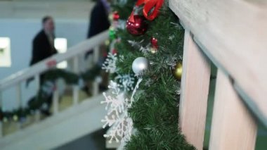 Carnival, holiday season. Pine branches decorated for Christmas against the background of people in antique costumes climbing the stairs. The camera is moving. Hand held.