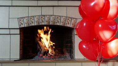 Sevgililer Günü, 8 Mart 'ta Uluslararası Kadınlar Günü. Helyum dolu, kırmızı kalp şeklinde balonlar şöminenin yanında duruyor..