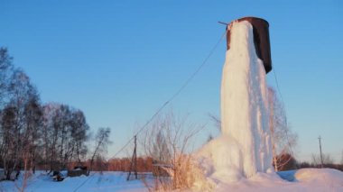 Su kaynağı. Bölgedeki bir su kulesinden donmuş bir şelale. Sibirya 'da. Elle tutulur.