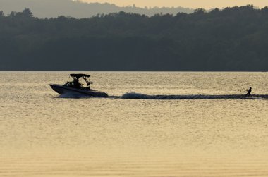 genç adam günbatımı sırasında jet ski üzerinde seyir