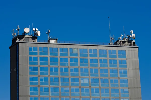 Edifício de escritórios com sistemas de rádio no telhado — Fotografia de Stock