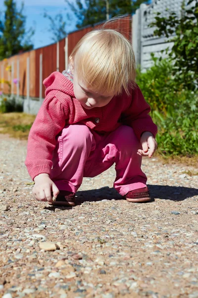 Kleines Mädchen spielt mit Kieseln — Stockfoto