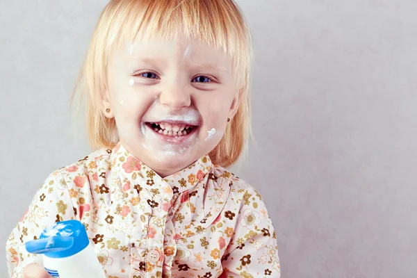 Glad liten flicka med body cream — Stockfoto