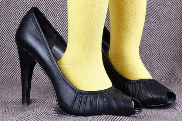 Una niña en zapatos de tacón alto de mujer — Foto de Stock